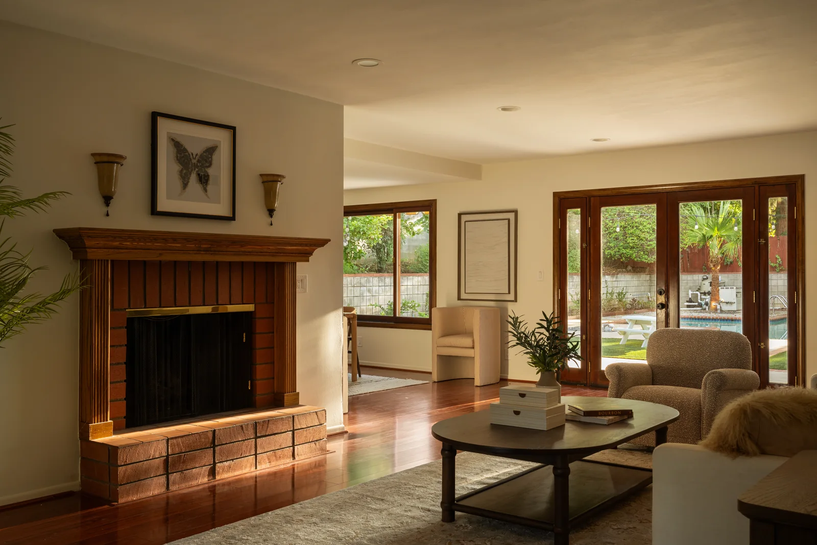 A sunlit living room with a stone fireplace